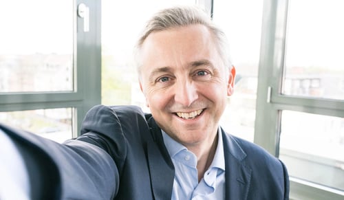 Trusted Shops CEO/PDG Jean-Marc Noel sourit à la caméra et fait un selfie dans son bureau
