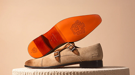Chaussures en cuir marron avec semelle orange.
